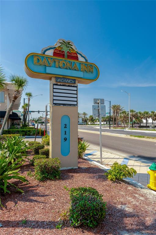 A tall, beige Daytona Inn sign stands on a landscaped roadside near a street — 219 S ATLANTIC AVENUE UNIT 237, DAYTONA BEACH, FL
