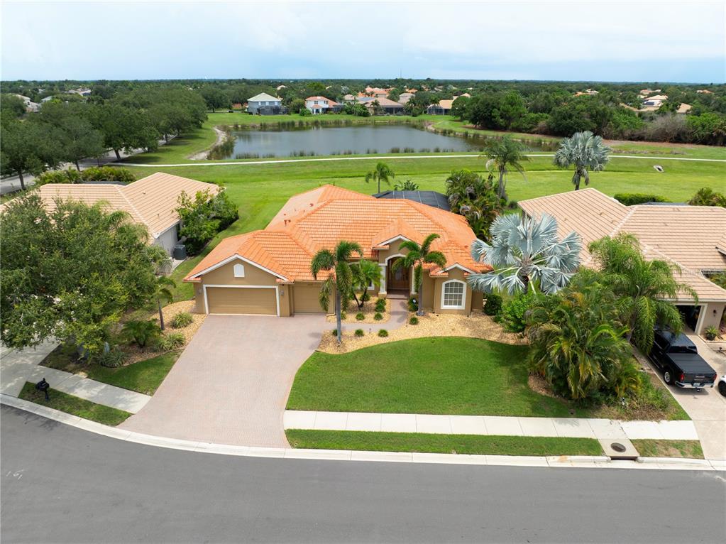 An aerial view of a single-story house with a tile roof and a front driveway — 12709 PENGUIN DRIVE, BRADENTON, FL