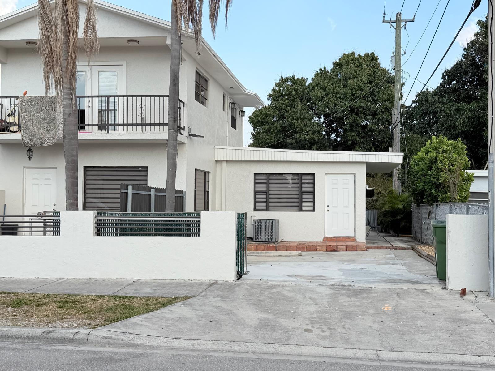 A two-story white stucco building with a flat-roofed addition and a concrete driveway — 1390 W 37th Street # 101, Hialeah FL 33012, HIALEAH, FL