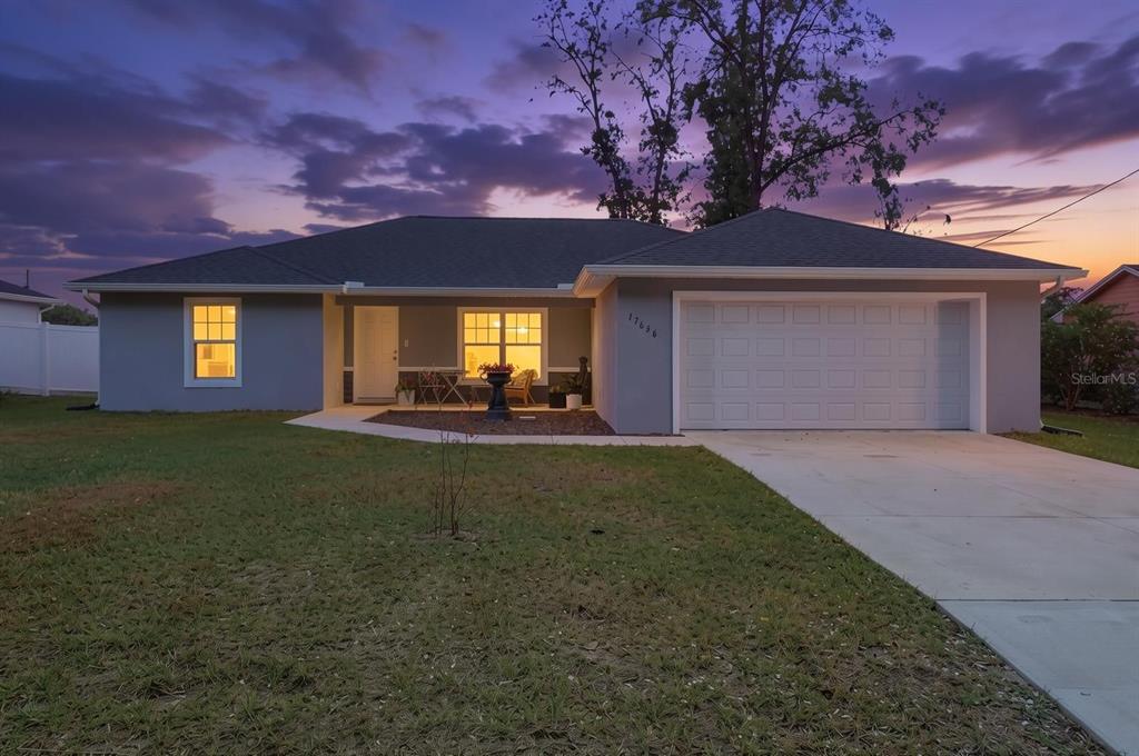 A single-story house with a gray exterior, a two-car garage, and a front lawn — 17636 SW 114TH STREET, DUNNELLON, FL