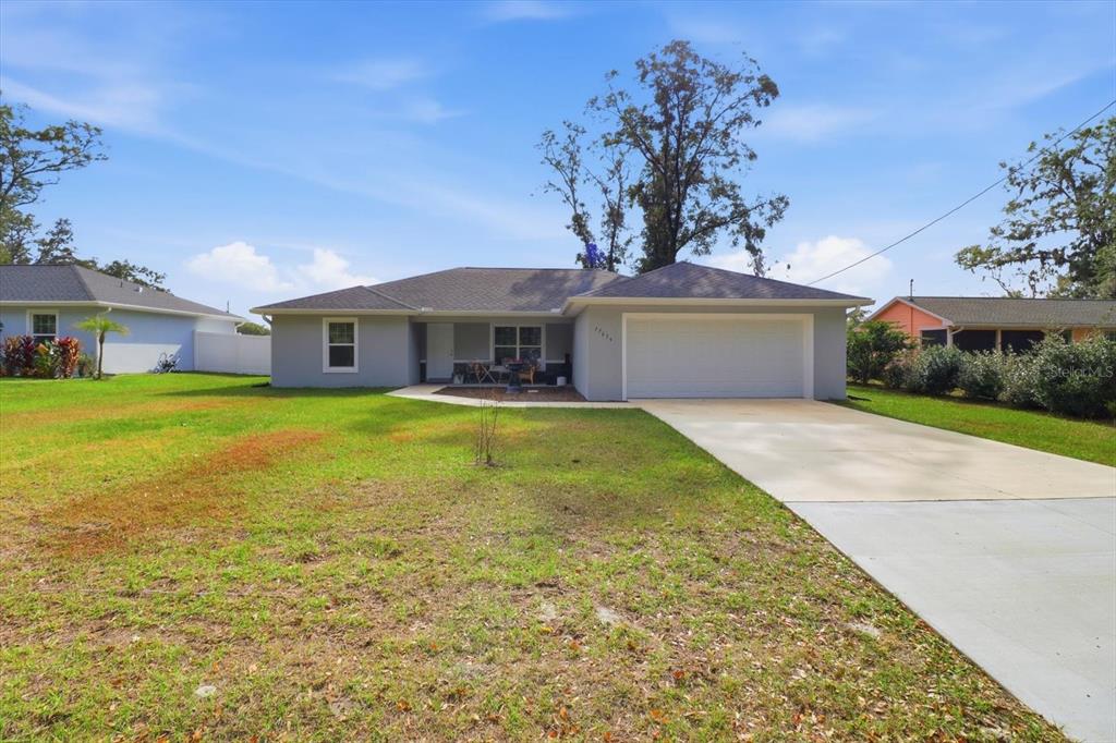 A single-story house with a gray exterior, a two-car garage, and a concrete driveway — 17636 SW 114TH STREET, DUNNELLON, FL