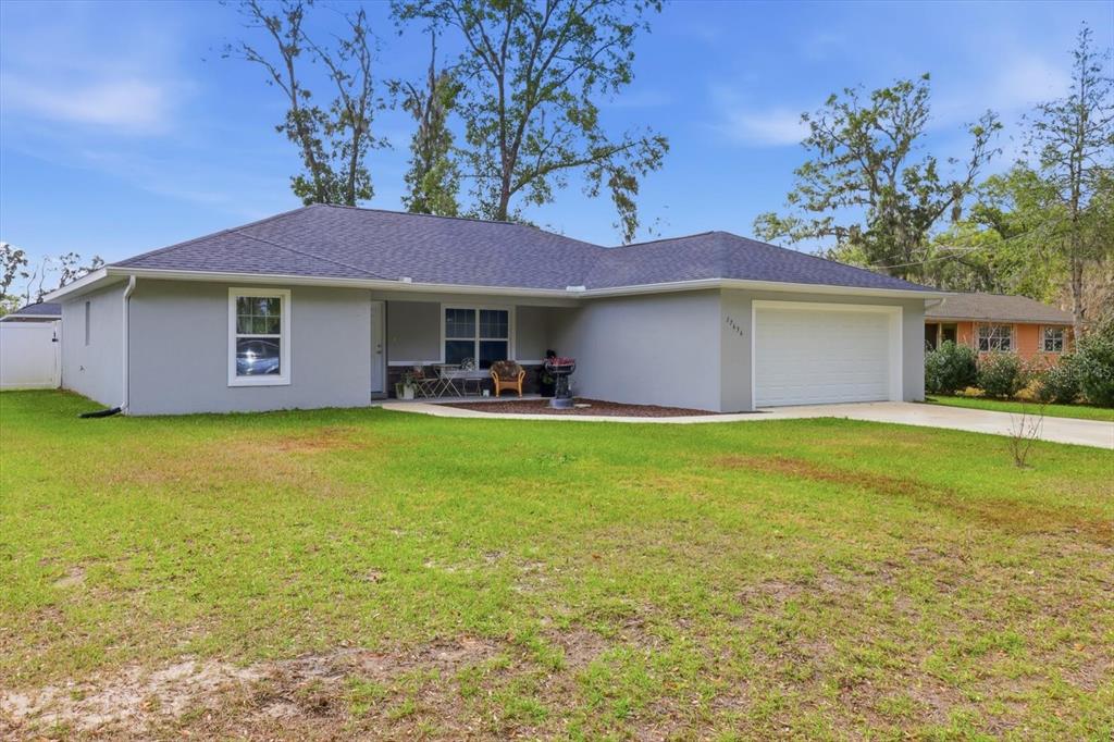 A single-story gray house with a white garage door and a front porch — 17636 SW 114TH STREET, DUNNELLON, FL