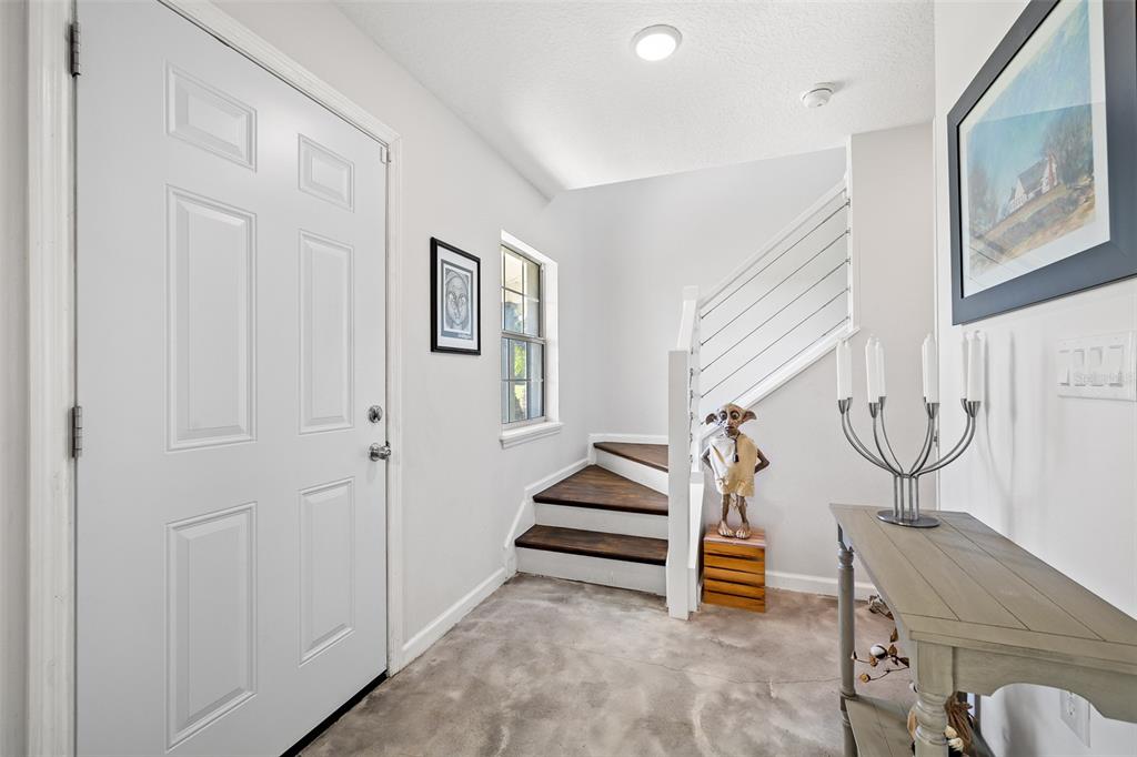 An entryway features a white front door, a staircase with dark wood treads, and a console — 4245 HENRY J AVENUE, ST CLOUD, FL
