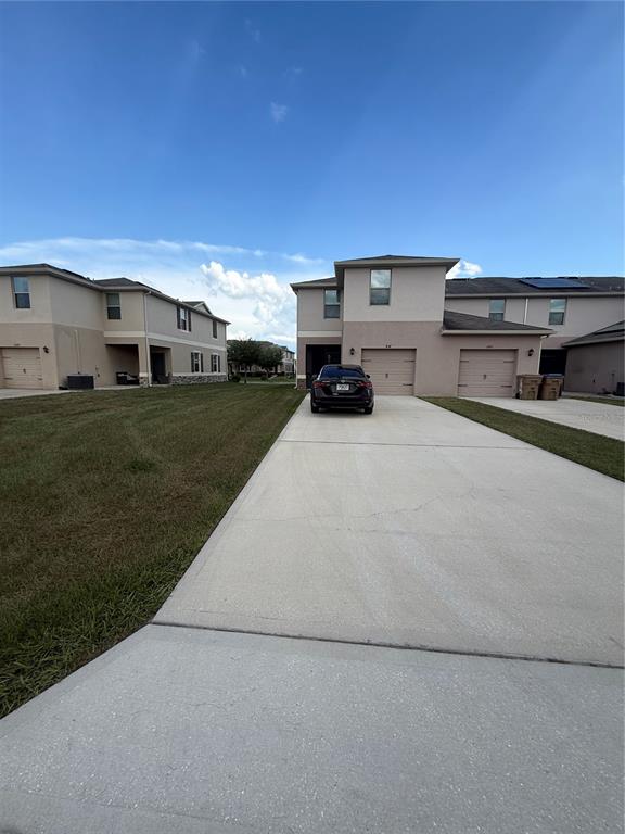 A dark sedan is parked in the driveway of a two-story suburban house — 1847 RED CANYON DRIVE, KISSIMMEE, FL