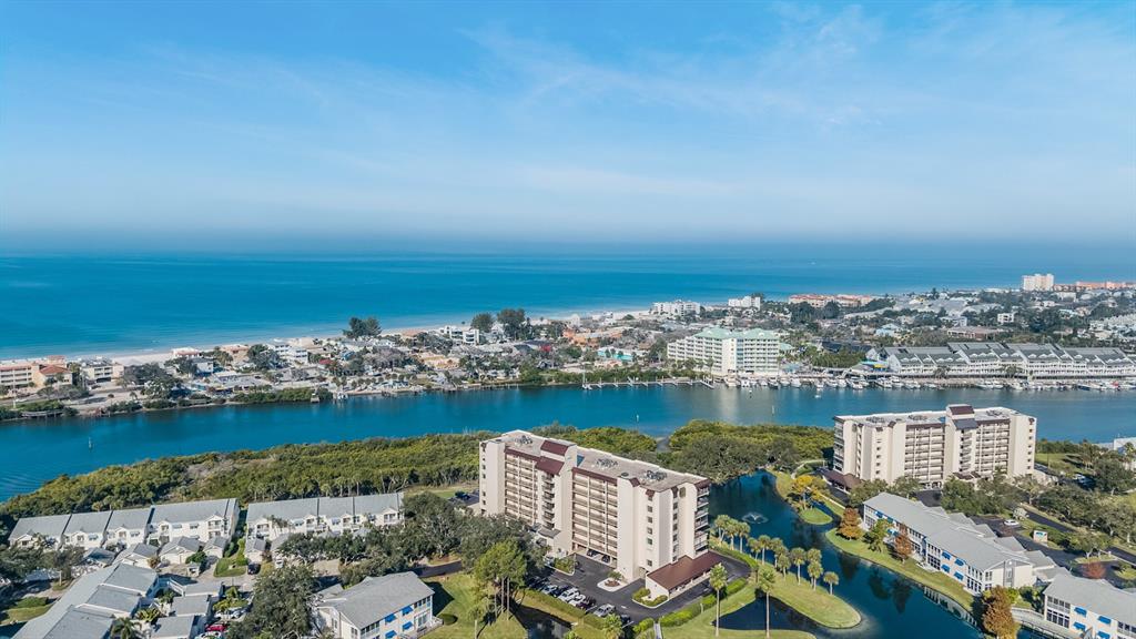 An aerial view shows multi-story apartment buildings, a waterway, and a beach along the coast — 11590 SHIPWATCH DRIVE UNIT 347, LARGO, FL