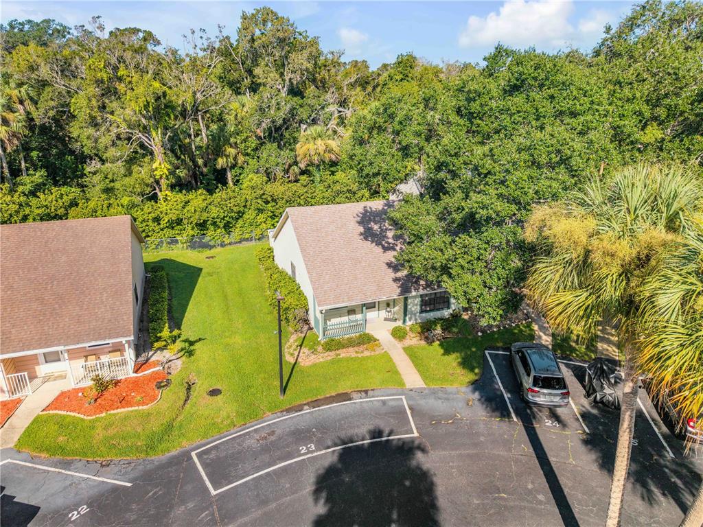 An aerial view shows a residential building with a brown roof and adjacent parking spaces — 232 N RIDGEWOOD AVENUE UNIT 23, EDGEWATER, FL