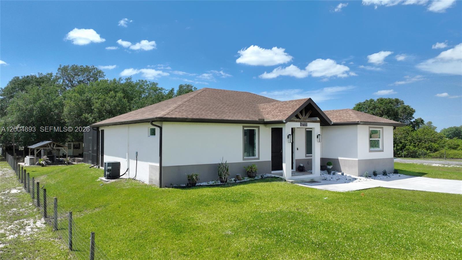 A single-story house with a white exterior, brown roof, and a covered front entryway — 7655 17th Place, La Belle FL 33935, LA BELLE, FL
