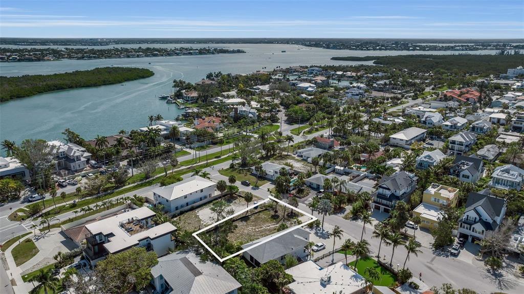 An aerial view shows a vacant rectangular lot near a beach and coastal residential area — 243 COOLIDGE DRIVE, SARASOTA, FL