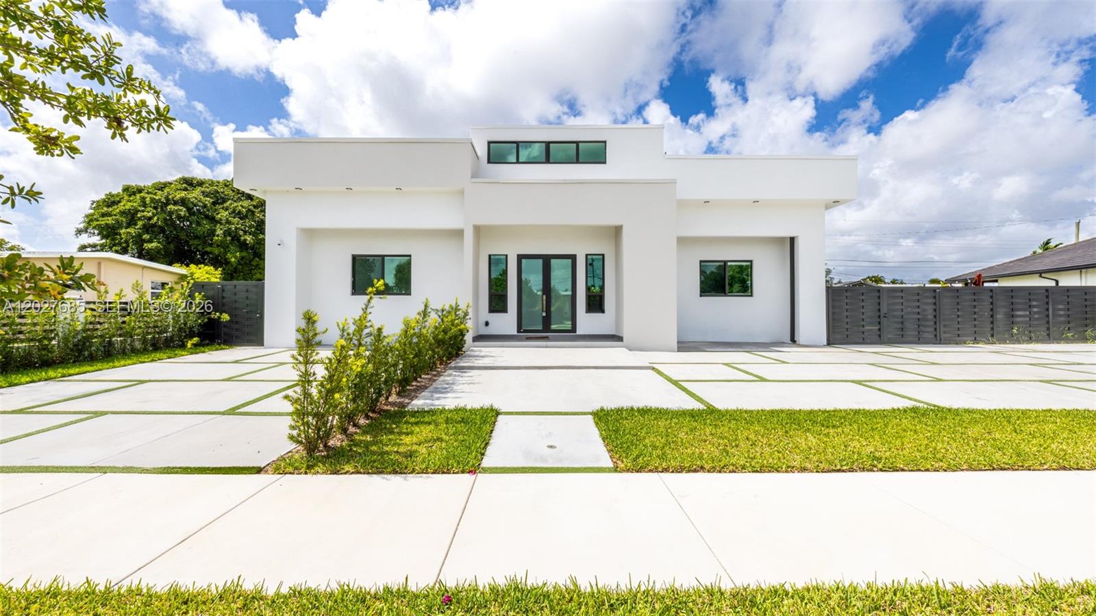 A modern white single-story house features a flat roof, large windows, and a concrete driveway — 11450 SW 59th Ter, Miami FL 33173, MIAMI, FL