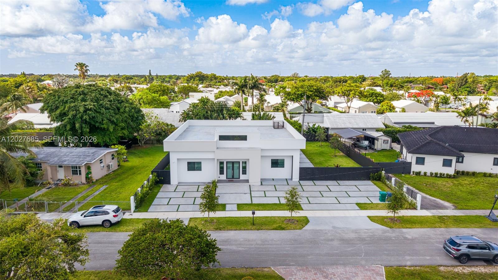 An aerial view shows a modern white house with a flat roof and a paved driveway — 11450 SW 59th Ter, Miami FL 33173, MIAMI, FL