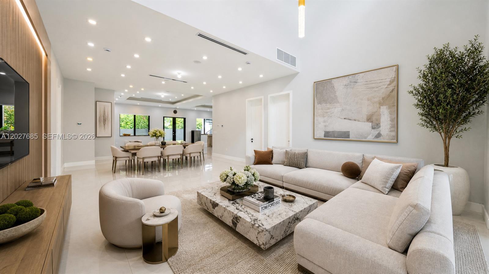 A modern living and dining area features a marble coffee table, sectional sofa, and lighting — 11450 SW 59th Ter, Miami FL 33173, MIAMI, FL