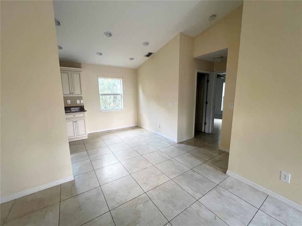 A kitchen area features light-colored tile flooring, beige walls, recessed lighting, and white cabinetry — 3281 EASY STREET, PORT CHARLOTTE, FL