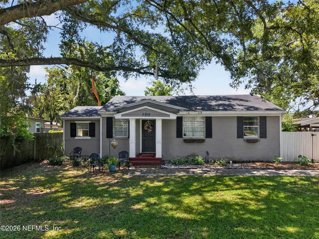 A single-story gray brick house with black shutters and a covered front porch entrance — 3308 SHERIDAN ROAD, JACKSONVILLE, FL