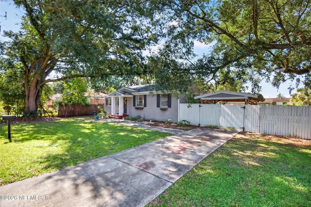 A single-story house with a gray brick exterior, a front porch, and a concrete driveway — 3308 SHERIDAN ROAD, JACKSONVILLE, FL
