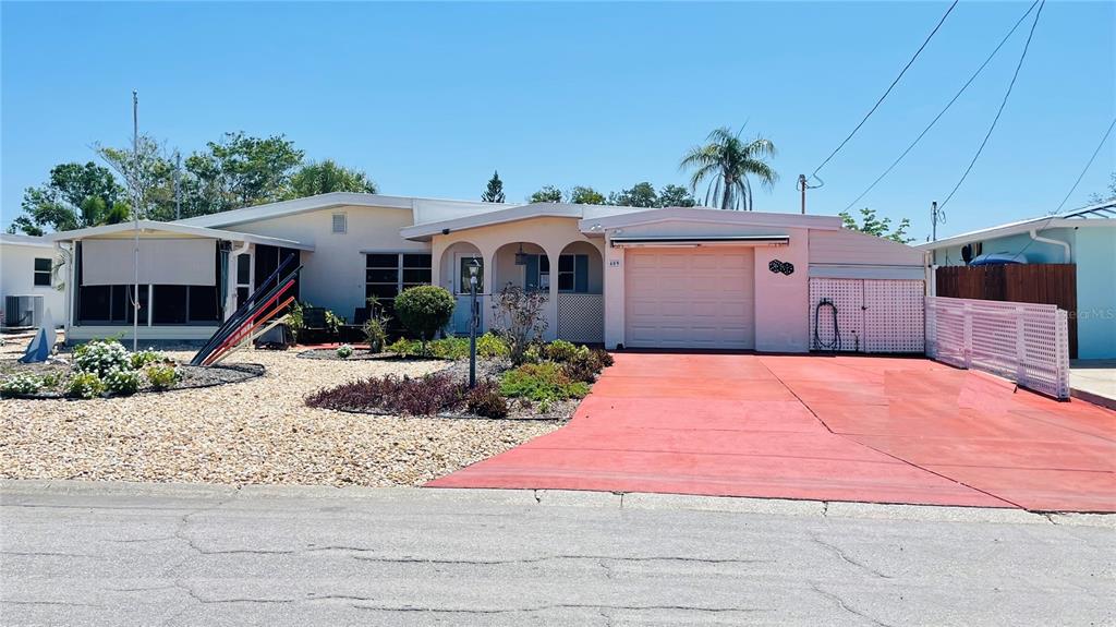 A single-story house with a red driveway, a garage, and a screened-in porch — 409 BRYN MAWR ISLAND, BRADENTON, FL