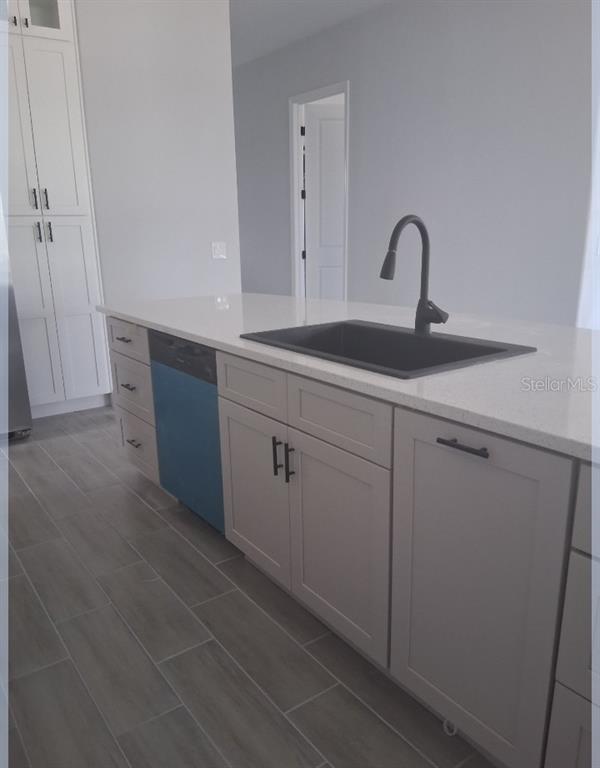 A kitchen island features a black sink, matte black faucet, and light gray cabinetry — 799 SW WHITE CLOUD STREET SW, PALM BAY, FL