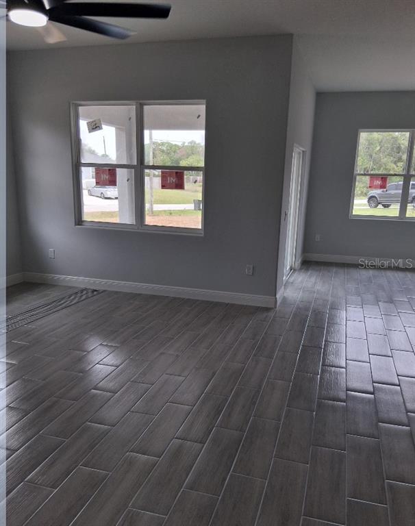 An interior view of a room with gray wood-look tile flooring and two windows — 799 SW WHITE CLOUD STREET SW, PALM BAY, FL