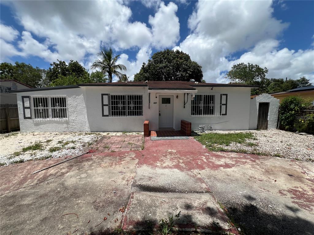 A single-story white house with security bars on the windows and a concrete driveway — 845 NW 130TH STREET, NORTH MIAMI, FL