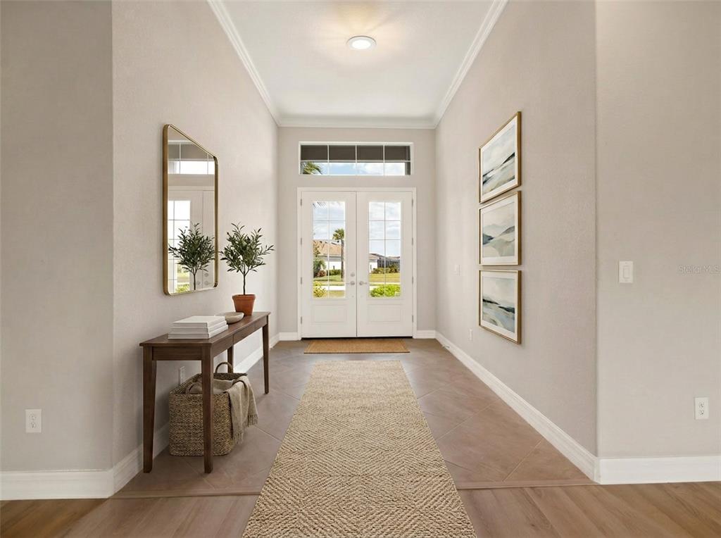 A bright entryway features a console table, a mirror, wall art, and a runner rug — 14500 PONCE DE LEON TRAIL, PORT CHARLOTTE, FL
