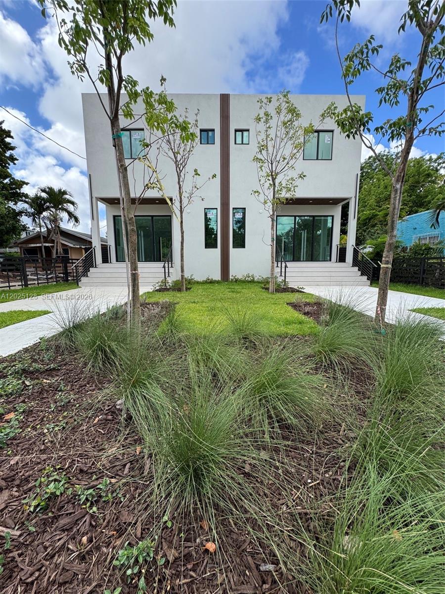 A modern two-story duplex with white stucco siding and glass sliding doors — 1924 NW 27th St, Miami FL 33142, MIAMI, FL