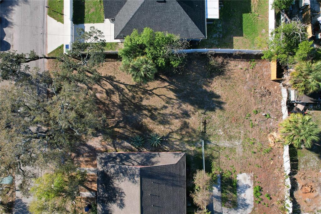 An aerial view shows a vacant residential lot situated between two houses with mature trees — 3222 N 48TH STREET, TAMPA, FL
