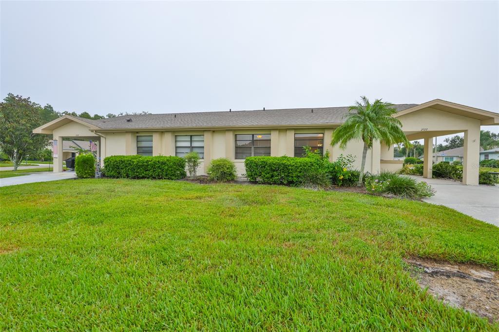 A single-story house with a beige exterior, a shingled roof, and a front carport — 2122 HEREFORD DRIVE UNIT 511, SUN CITY CENTER, FL