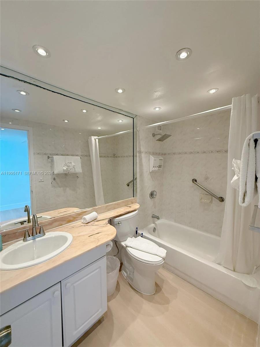 A bathroom features a vanity with a marble countertop, a toilet, and a shower-tub combination — 5445 Collins Ave # 635, Miami Beach FL 33140, MIAMI BEACH, FL
