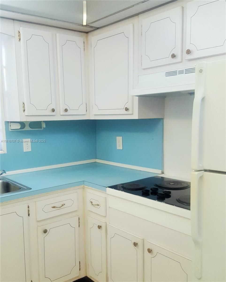 A kitchen features white cabinets, a blue countertop, and a blue backsplash — 19080 NE 3rd Ct # 318, Miami FL 33179, MIAMI, FL