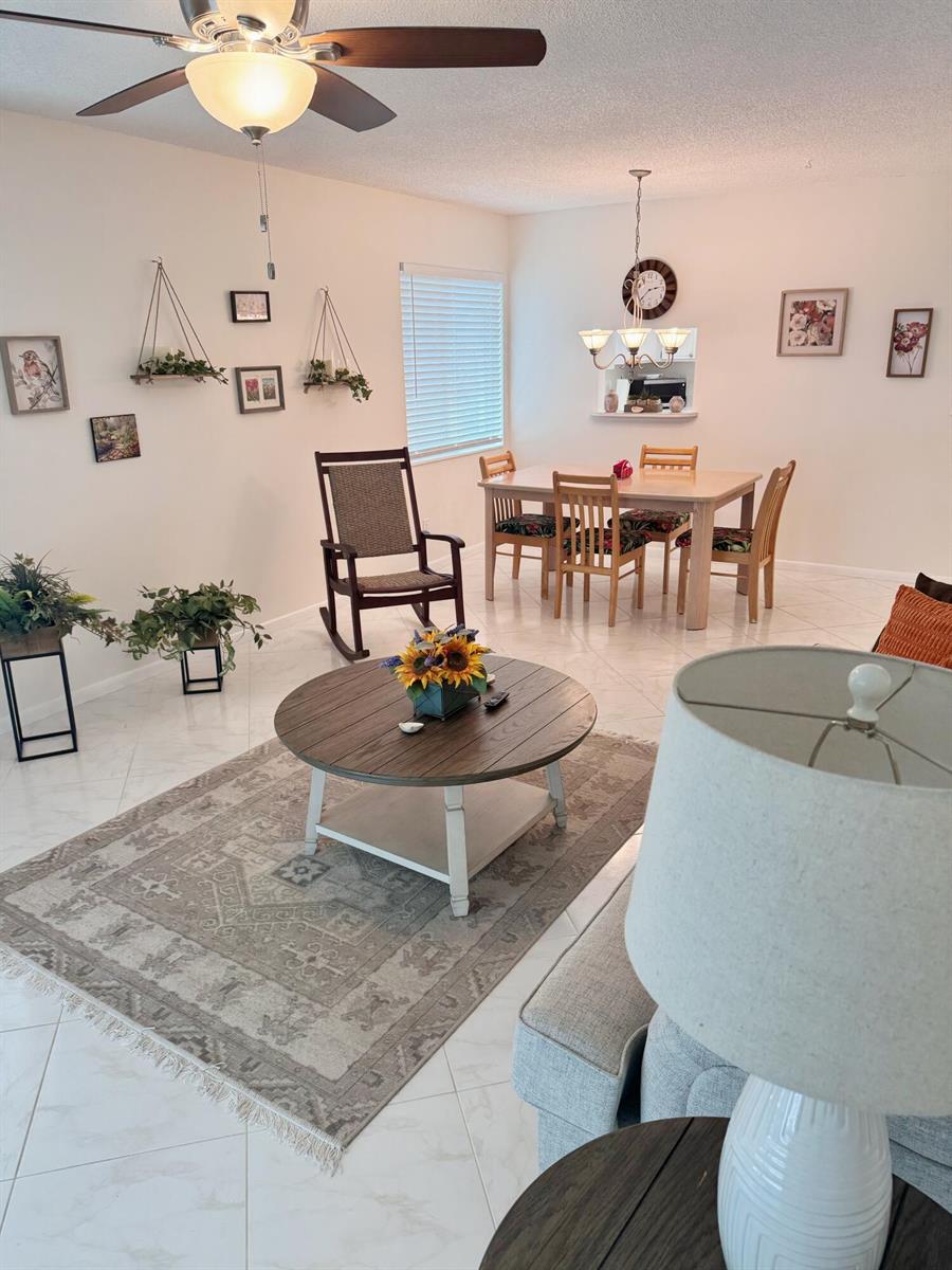 A living room and dining area with tile floors, a round coffee table, and a rug — 2950 SE Ocean Boulevard # 6, Stuart FL 34996, STUART, FL