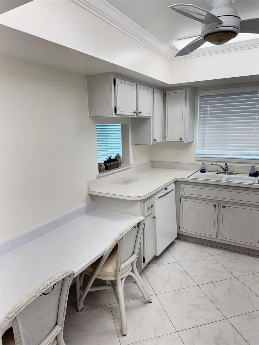 A kitchen features light wood-grain cabinets, white countertops, a dishwasher, and a breakfast bar area — 2950 SE Ocean Boulevard # 6, Stuart FL 34996, STUART, FL