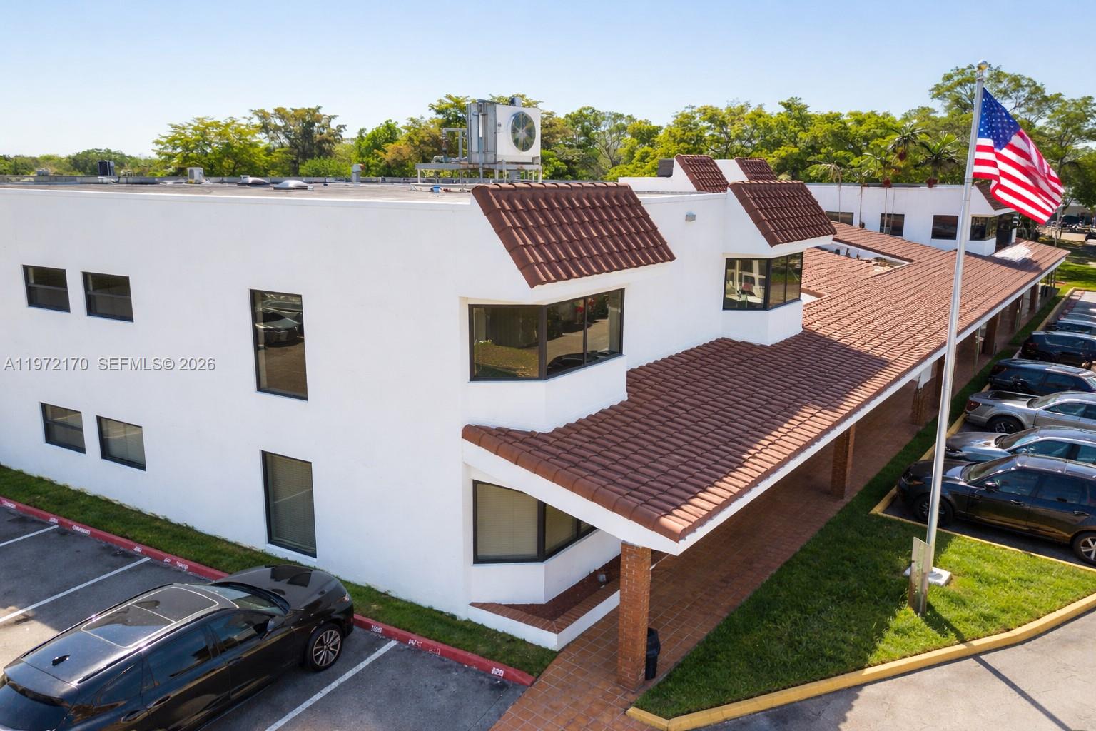 An aerial view shows a white two-story commercial building with a brown tiled roof — 5969 NW 151st St, Miami Lakes FL 33014, MIAMI LAKES, FL