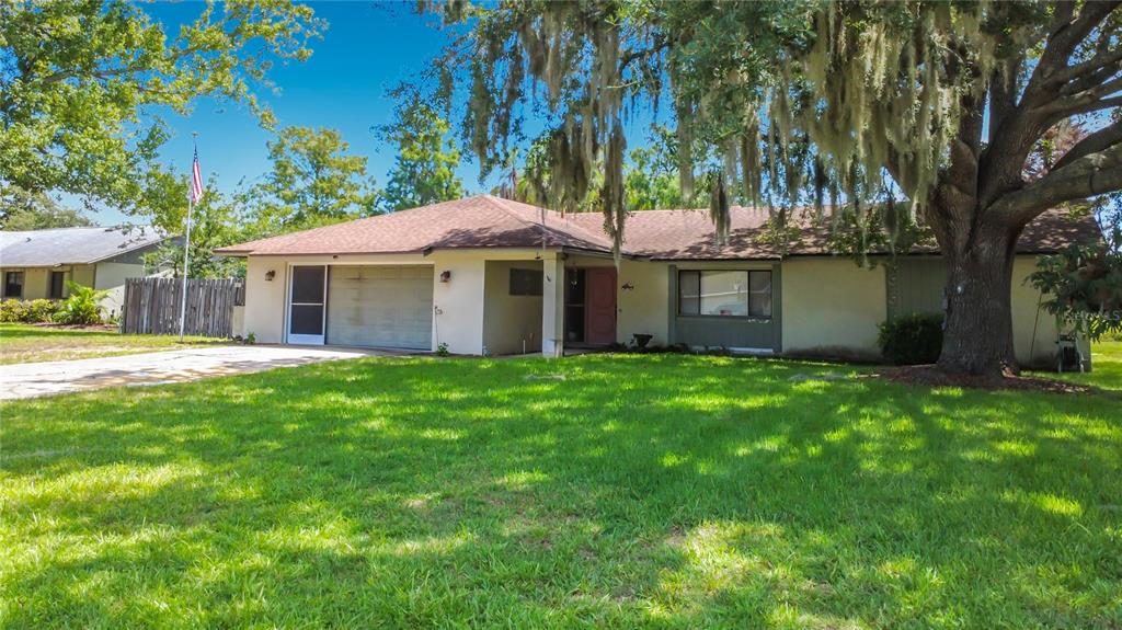 A single-story house with a garage, a front porch, and a large oak tree — 28800 TAMMI DRIVE, TAVARES, FL