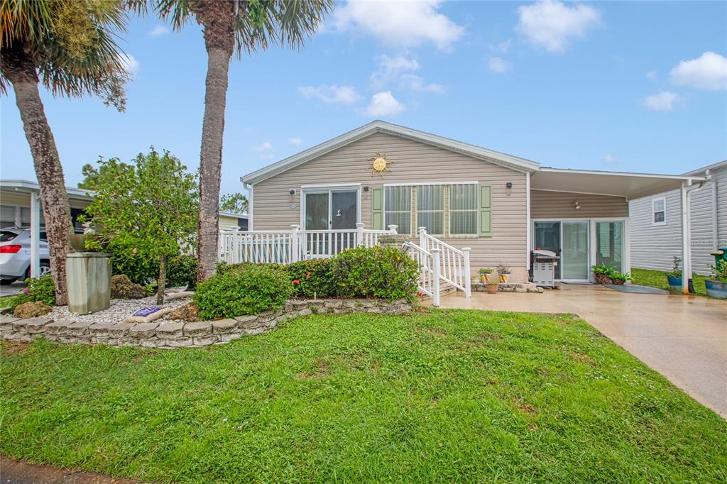A single-story house with light siding, a front deck, and a covered carport — 2100 KINGS HIGHWAY UNIT 685, PUNTA GORDA, FL