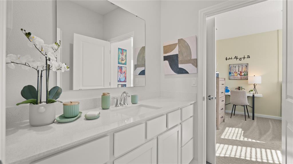 A white bathroom vanity with a mirror and sink, viewed through a doorway into a bedroom — 4378 BENTGRASS BEND, ST CLOUD, FL