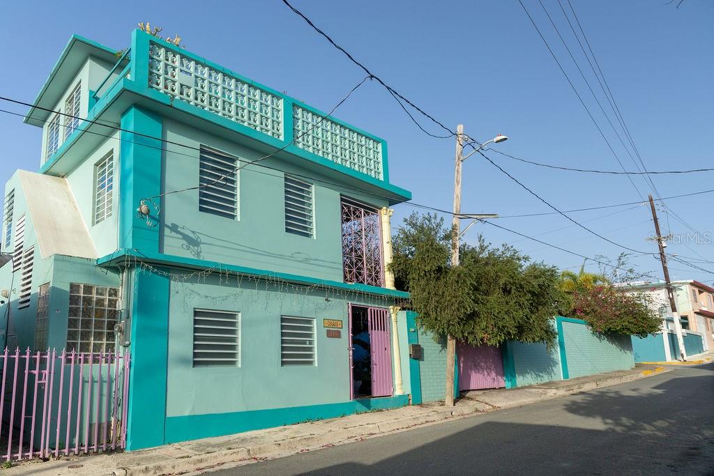 A two-story teal building with decorative concrete blocks and metal security bars on the windows — 220 CALLE PRUDENCIO QUIÑONES, VIEQUES, PR
