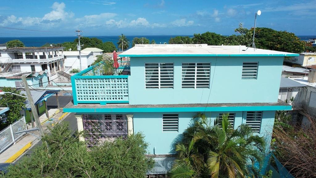 An aerial view of a two-story turquoise house with a rooftop terrace overlooking the ocean — 220 CALLE PRUDENCIO QUIÑONES, VIEQUES, PR