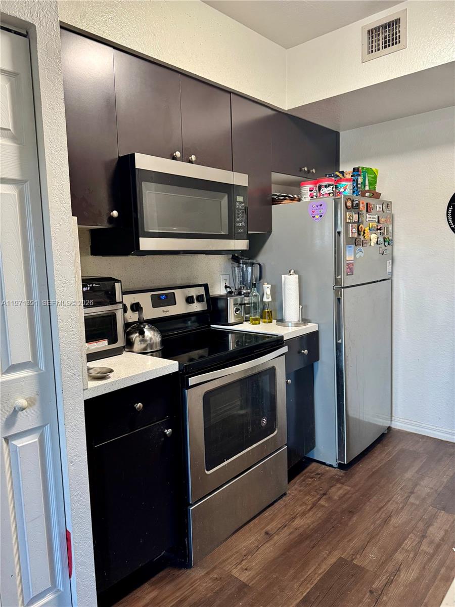 A kitchen features dark cabinets, stainless steel appliances, and light-colored countertops — 2517 Centergate Dr # 203, Miramar FL 33025, MIRAMAR, FL