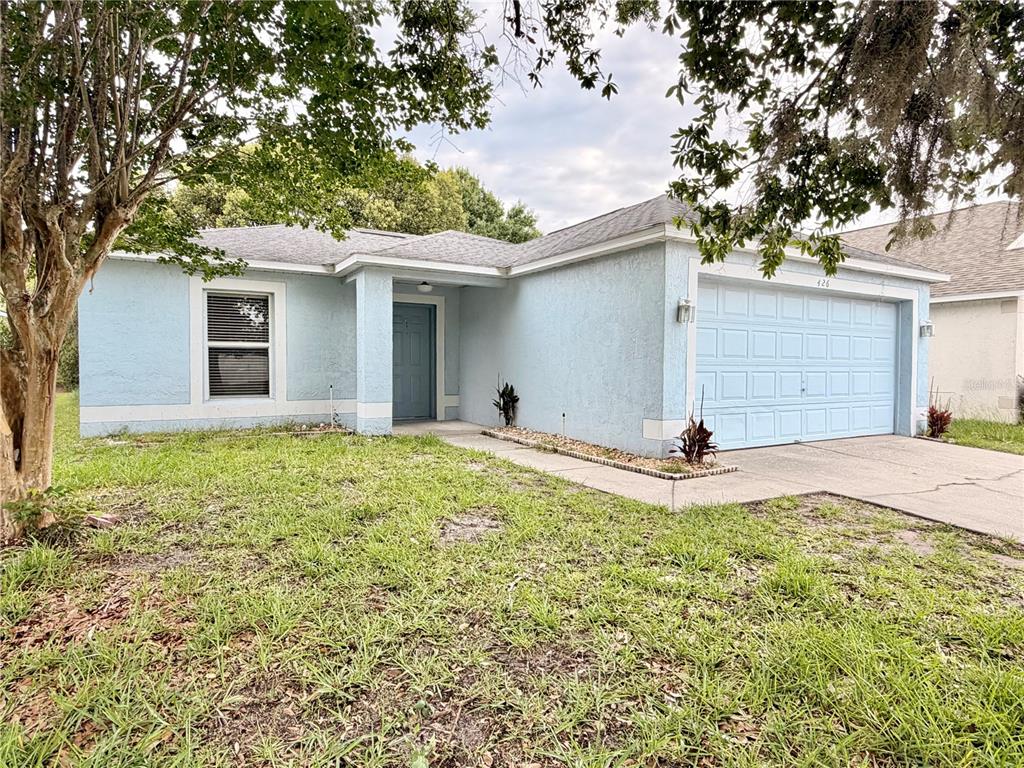 A light blue, single-story house with a two-car garage and a front entrance — 426 WOODBURY PINES CIRCLE, ORLANDO, FL