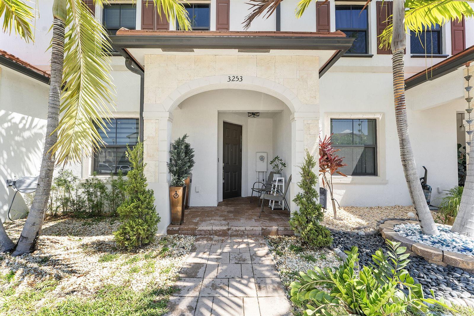 The exterior of a two-story house features a stone-arched entryway and a paved walkway — 3253 W 106th Terrace # 3253, Hialeah FL 33018, HIALEAH, FL