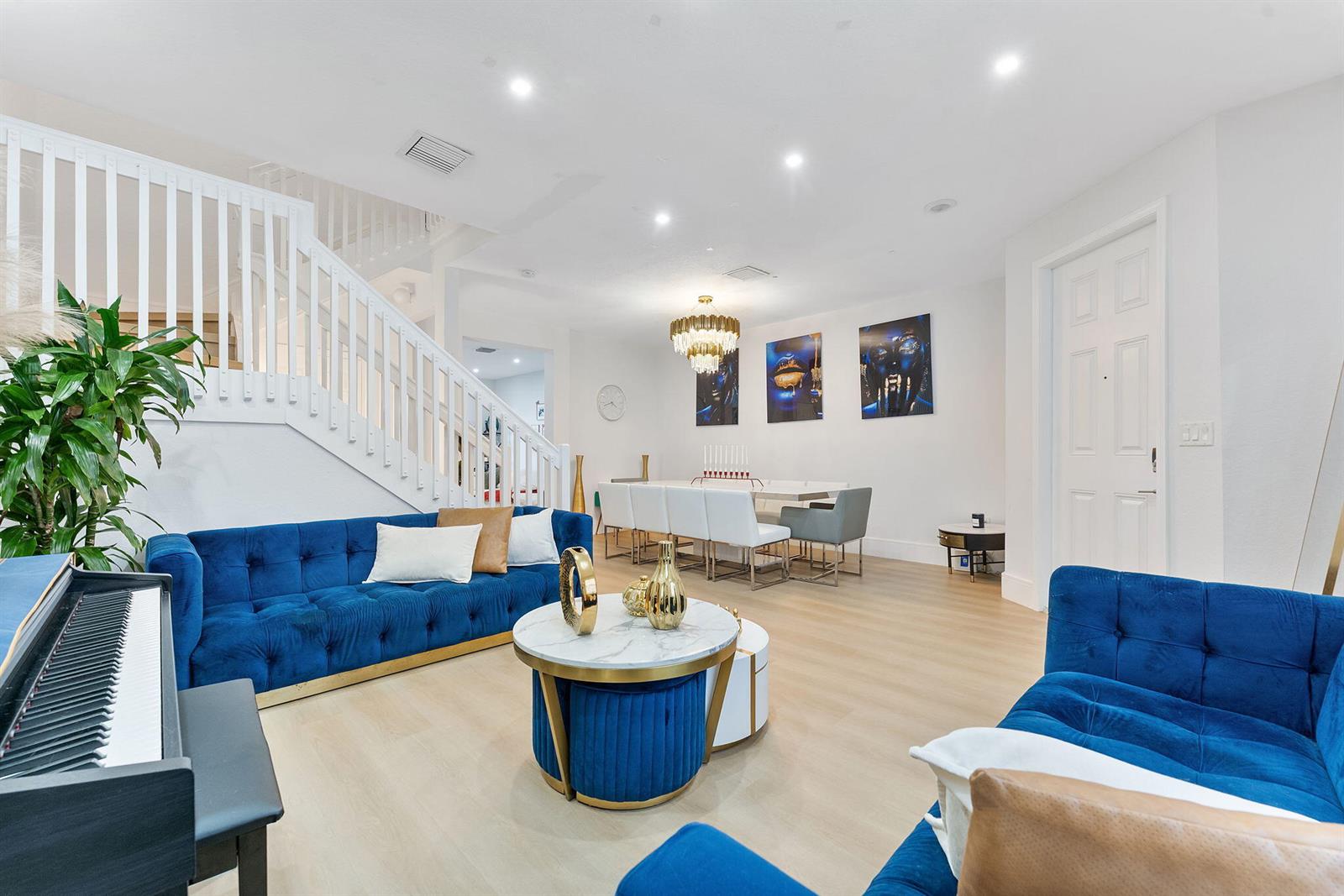 A living and dining area features blue tufted sofas, a marble coffee table, and stairs — 3253 W 106th Terrace # 3253, Hialeah FL 33018, HIALEAH, FL