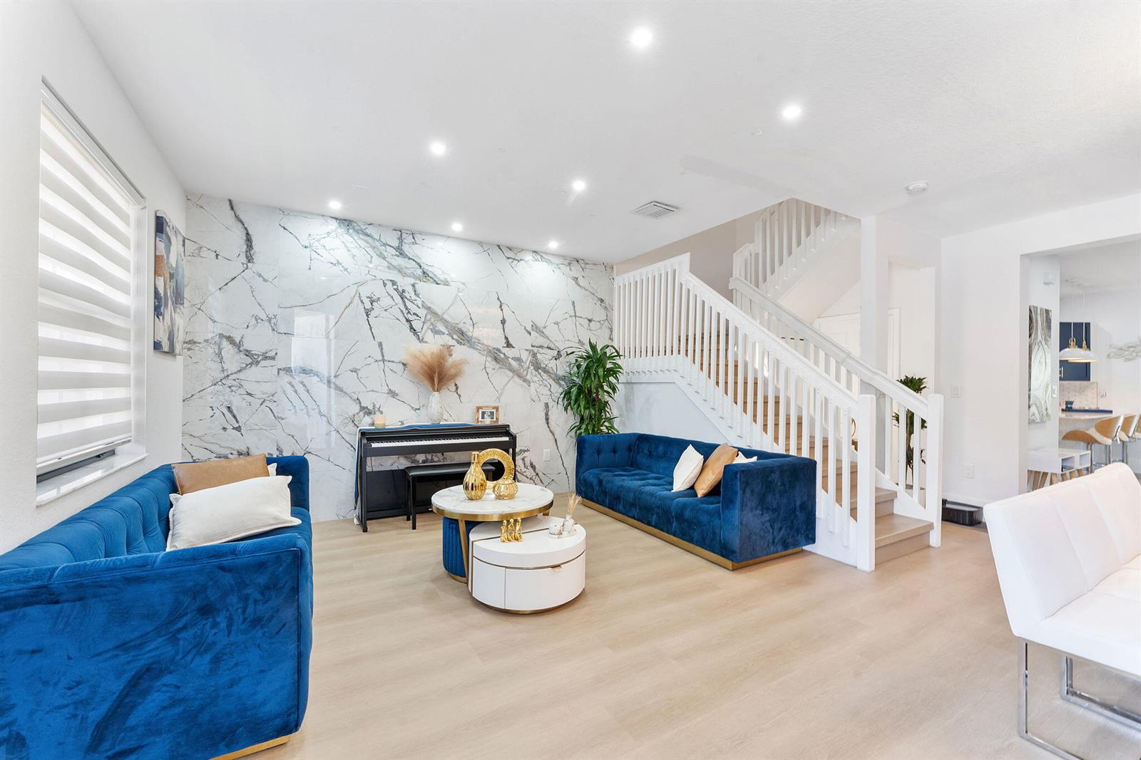 A living room features two blue velvet sofas, a marble accent wall, and a staircase — 3253 W 106th Terrace # 3253, Hialeah FL 33018, HIALEAH, FL