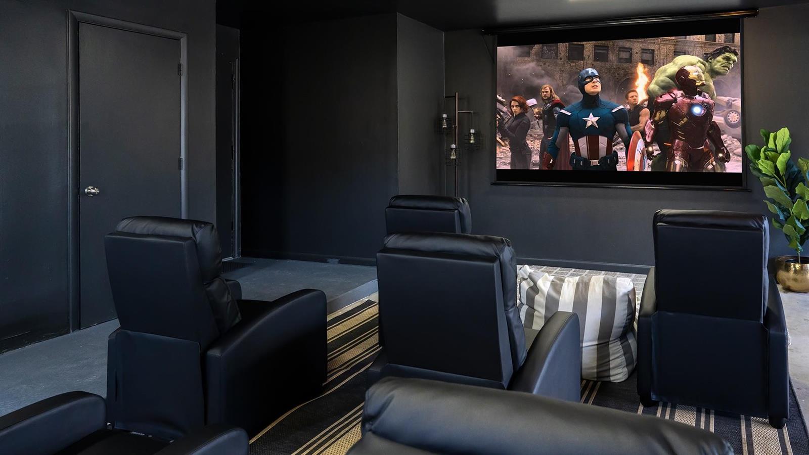 A home theater room features black walls, a projector screen, and rows of leather recliners — 518 Sunshine Drive, Delray Beach FL 33444, DELRAY BEACH, FL