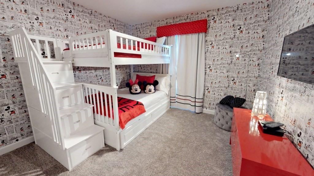 A bedroom features a white bunk bed with stairs, Mickey Mouse wallpaper, and a red dresser — 4966 WINDERMERE AVENUE, KISSIMMEE, FL