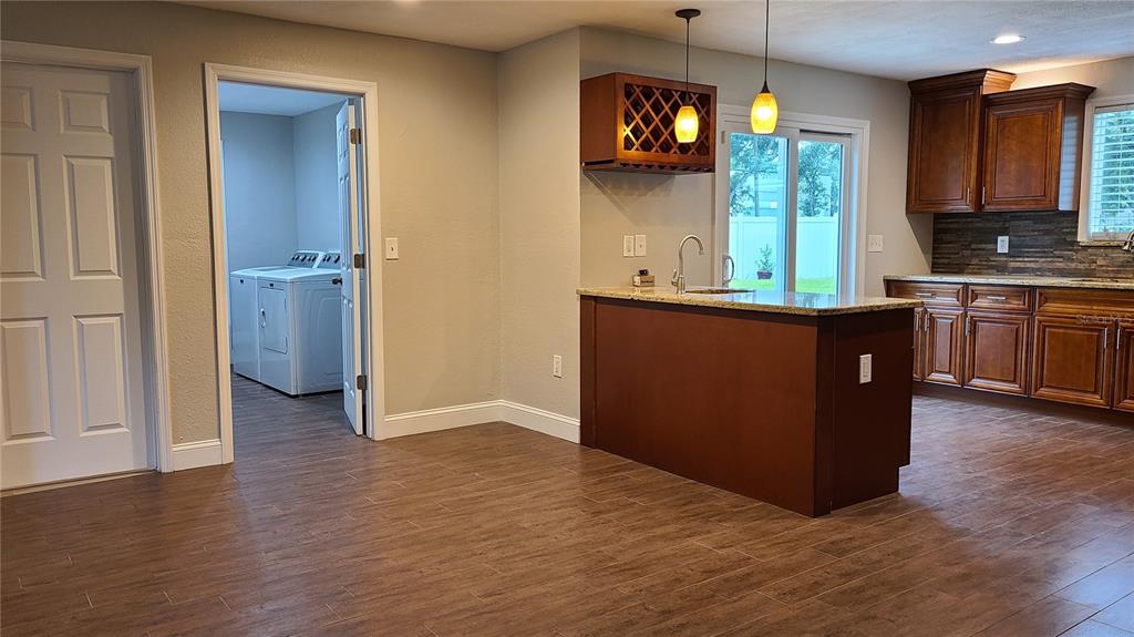 A kitchen with a wooden island, dark cabinets, and an adjacent laundry room doorway — 1718 CARDINAL DR, CLEARWATER, FL