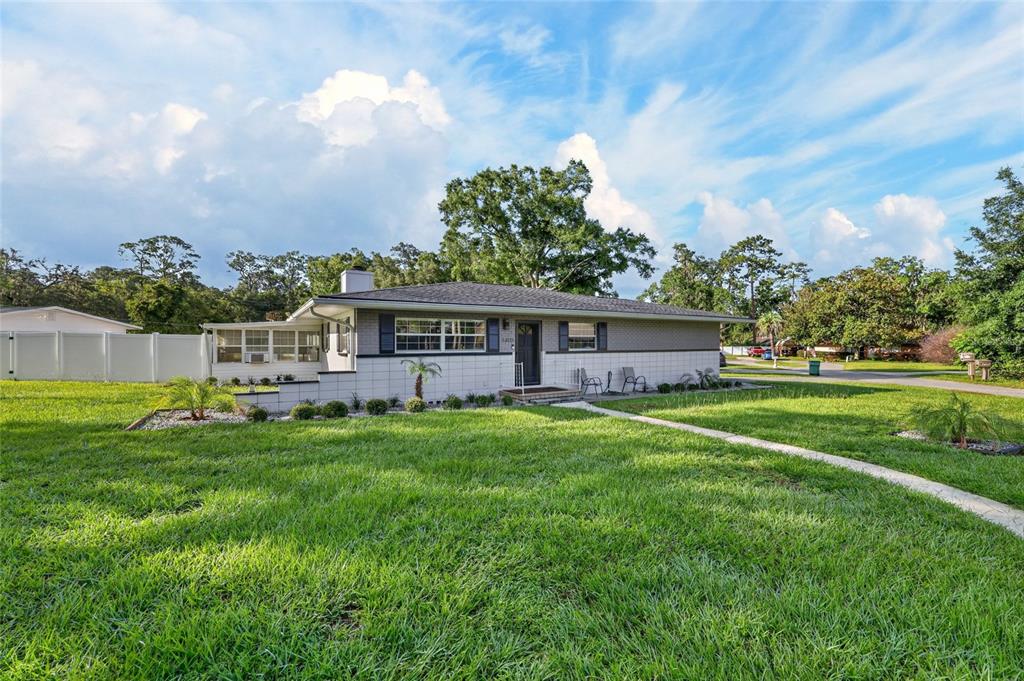 A single-story house with a gray exterior, white block accents, and a large front lawn — 3408 SE 13TH PLACE, OCALA, FL