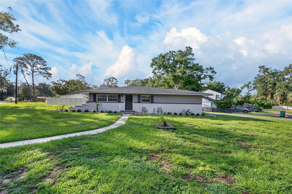 A single-story ranch-style house with a gray brick exterior and a front walkway — 3408 SE 13TH PLACE, OCALA, FL