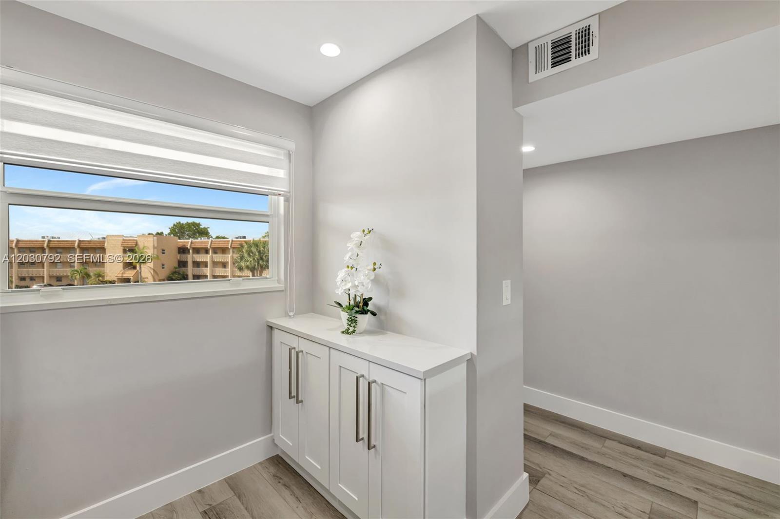 A white cabinet with a stone top sits beneath a window in a room with gray walls — 6800 Royal Palm Blvd # 302F, Margate FL 33063, MARGATE, FL