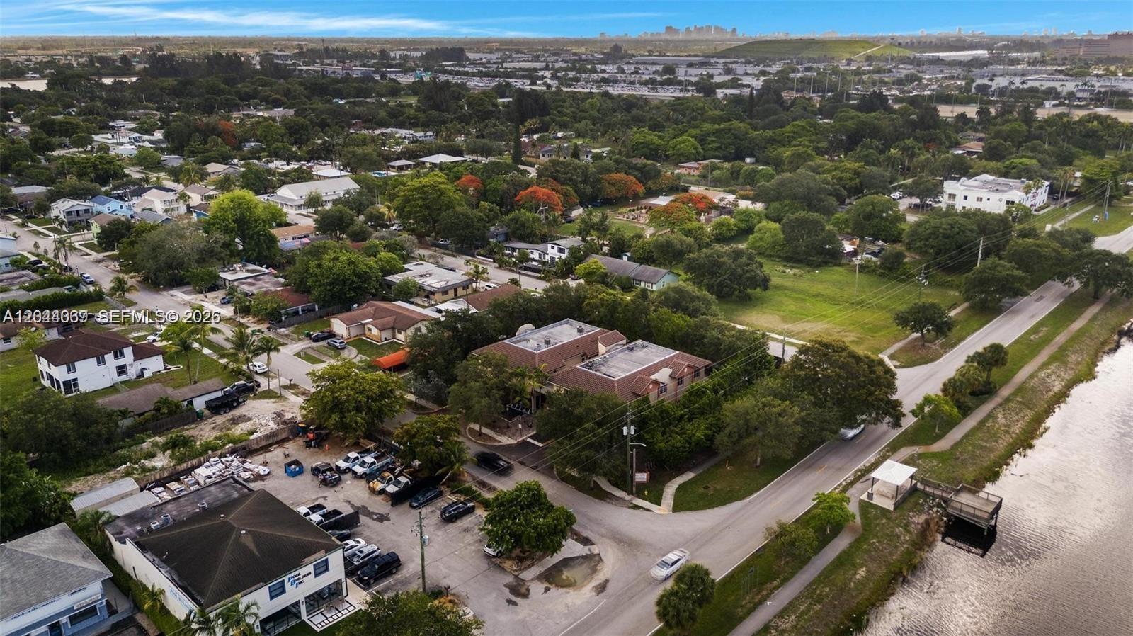 An aerial view shows a commercial building, a parking lot, and a nearby residential neighborhood — 5595 Orange Dr # 101, Davie FL 33314, DAVIE, FL