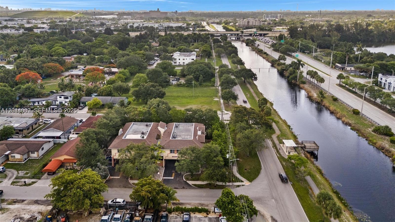 An aerial view shows a two-story building next to a canal and a road — 5595 Orange Dr # 101, Davie FL 33314, DAVIE, FL