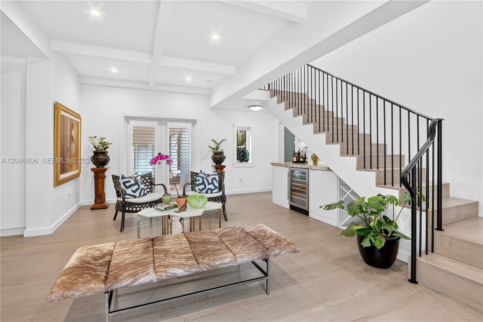 A living area features light wood floors, a staircase with black railings, and a bar — 100 Sarto Ave., Coral Gables FL 33134, CORAL GABLES, FL